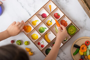 teaching preschoolers. the child recognizes products and distinguishes colors. polymer vegetables - obrazy, fototapety, plakaty