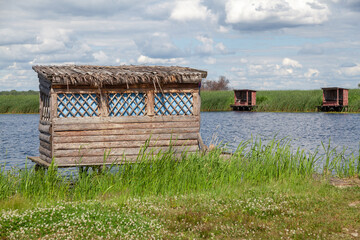 Wooden gazebo stands above  water of reservoir