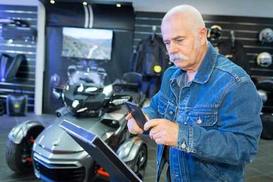 man in showroom reading qr code with smartphone