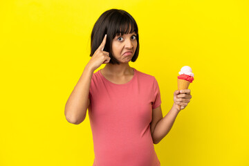 Pregnant woman holding a cornet ice cream isolated on yellow background thinking an idea