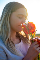  junge Frau mit Blumenstrauß  im Mohnfeld