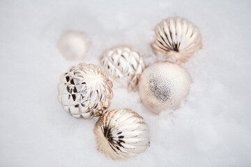 beautiful Christmas decorations on white snow top view. gently golden balls. festive background, selective focus