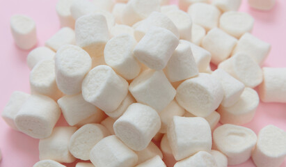 Fototapeta na wymiar Marshmallows on pink background. White fluffy mini dessert, sweet kids birthday party snack