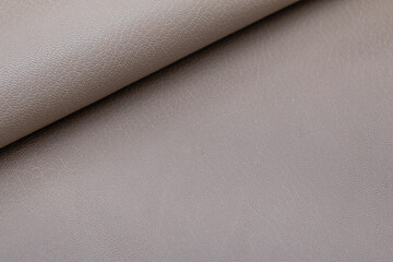 Grey folded natural cow leather on the wooden table	

