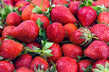 Fresh strawberry on black ceramic plate on white background. Summer fruit.