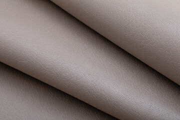 Grey folded natural cow leather on the wooden table	
