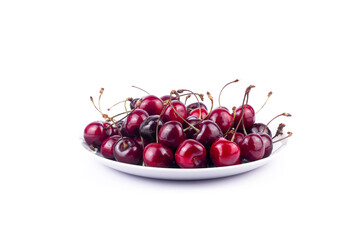 Sweet red cherry on white ceramic plate on white background.