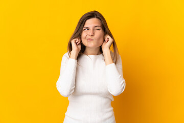 Young Slovak woman isolated on yellow background frustrated and covering ears