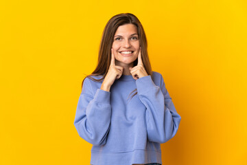 Young Slovak woman isolated on yellow background smiling with a happy and pleasant expression