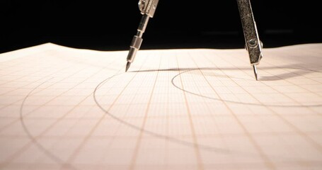 Macro of the compass drawing a circle on paper. Close up, side-view camera tracking. 4k - Powered by Adobe