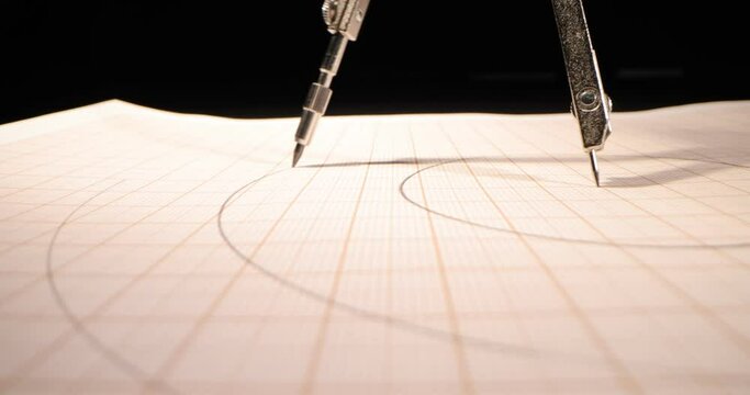 Macro of the compass drawing a circle on paper. Close up, side-view camera tracking. 4k