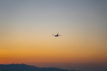 Fototapeta na wymiar Verkehrsflugzeug landet während eines Sonnenuntergangs / Jet Aircraft landing during sunset with beauftiful orange sky 