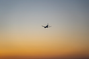 Jet Aircraft landing during sunset with beauftiful orange sky / Verkehrsflugzeug landet während eines Sonnenuntergangs