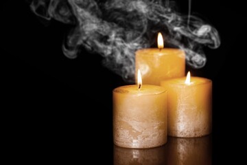 Candles over dark background. Used, almost extinguished. Burned out. Mystical smoke swirls in the...