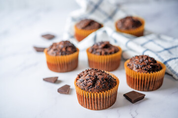 Chocolate muffins with chocolate sprinkles and glasses of coffee