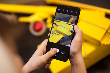 The boy makes a photo of wrapped gifts on his phone.