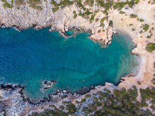 Eine Bucht mit türkisblauem Wasser und einem kleinen Strand an der der Mittelmeerküste auf Kreta in Griechenland, Drohnenfotografie / Luftaufnahme v