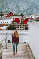 Tourist woman walking sightseeing Lofoten islands village in Norway Travel lifestyle outdoor summer...