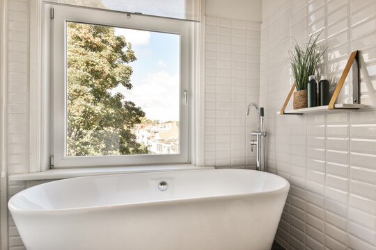 Bathtub placed near window in bathroom