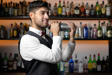 Bartender shaking cocktail shaker in cocktail bar. High quality photo