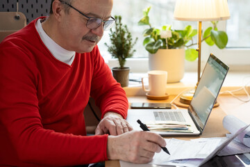 Senior man with eyeglasses counting money from retirement and control finance