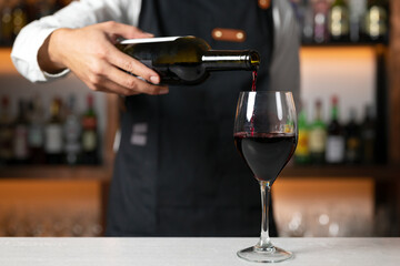 Fototapeta na wymiar Unrecognizable Bartender serving red wine. High quality photo