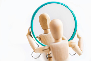 Wooden dummy looks at its reflection in the mirror