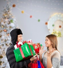 laughing man embracing happy wife with christmas presents in living room,