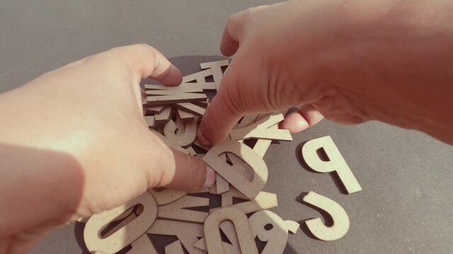 Close up hand picking up White DIY Word Wooden Letters Alphabet for Art Crafts Home Decor from table. Design decoration background Concept.