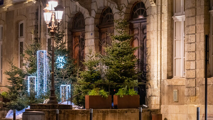 Fototapeta na wymiar Magnificent Christmas decoration in front of the town hall, at night, fir trees and light garlands.