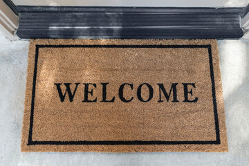 Clean welcome mat outside suburban front door.