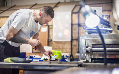 Technician making fridge magnet with soft PVC rubber in mold