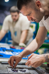 Technician making fridge magnet with soft PVC rubber in mold