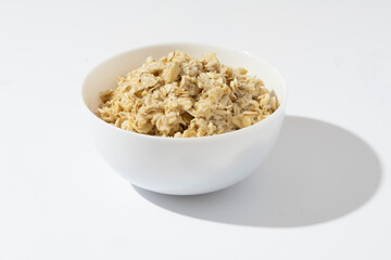 Bowl of oatmeal porridge on a white background. Healthy breakfast