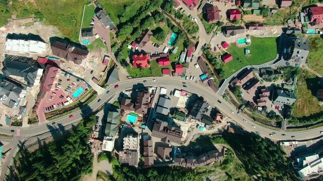 Aerial view over luxury cottages and hotels with swimming pools and green lawns. Beautiful residential complex in summer holiday destination, Bukovel, Ukraine. High quality 4k footage