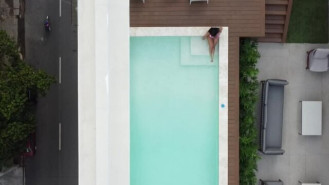santo domingo, republica dominicana -  15 diciembre 2021 - vista de drone mostrando chica en bikini disfrutando de hermosa piscina vacia.