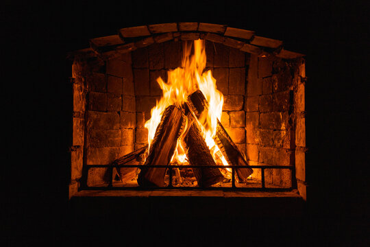 Glowing fire in home stone fireplace