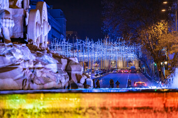 Statue of the goddess Cibeles with the two lions and Christmas lighting during a dark winter night in the emblematic Plaza de Cibeles in the city of Madrid, Spain
