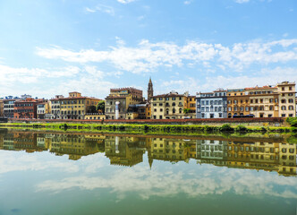 view of Florence`s buildings reflected in the waters of Arno River - Florence, Italy