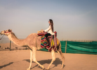 KUWAIT - Woman riding a camel in Kuwait.