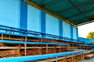 Old grandstand seats. Vintage tone. Old blue wooden grandstand stadium
