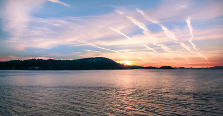 Setting sun behind the mountains over the Pacific Ocean