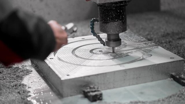 CNC operator blows the shavings from the aluminum mold. Numerical Control in Heavy Industry