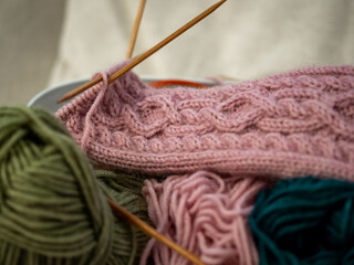 Craft basket with colorful wool yarns and a knitted decorative sock