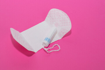 Sanitary napkin and tampon on pink background. The concept of menstruation, protection, feminine hygiene during menstruation. Space for text, copy space