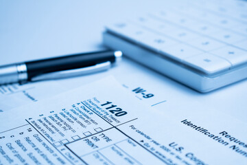 The tax forms with money and the pen. Tax Day concept.