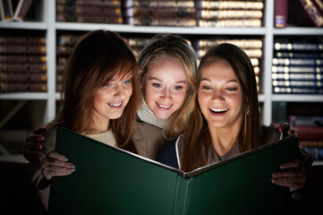 young students reading magic book in library