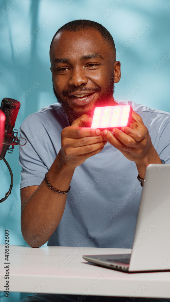 Aufkleber blogger doing product review of light with multiple colors on camera for vlog channel. vlogger revie