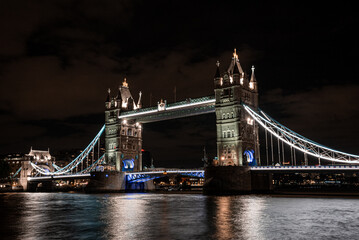Fototapeta na wymiar Iconic Tower Bridge view connecting London with Southwark over Thames River, UK. Beautiful view of the illuminated bridge at night.