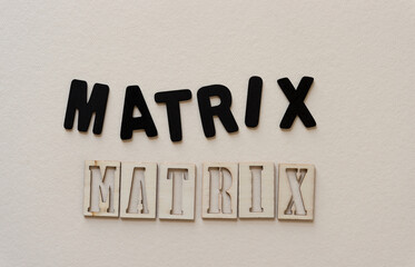 the word "matrix" in black chalk letters and wooden stencil font on paper